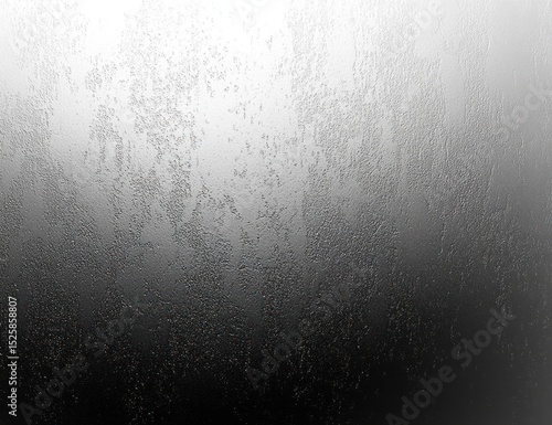 Close-up of a fogged glass window with water droplets creating a textured abstract pattern in grayscale