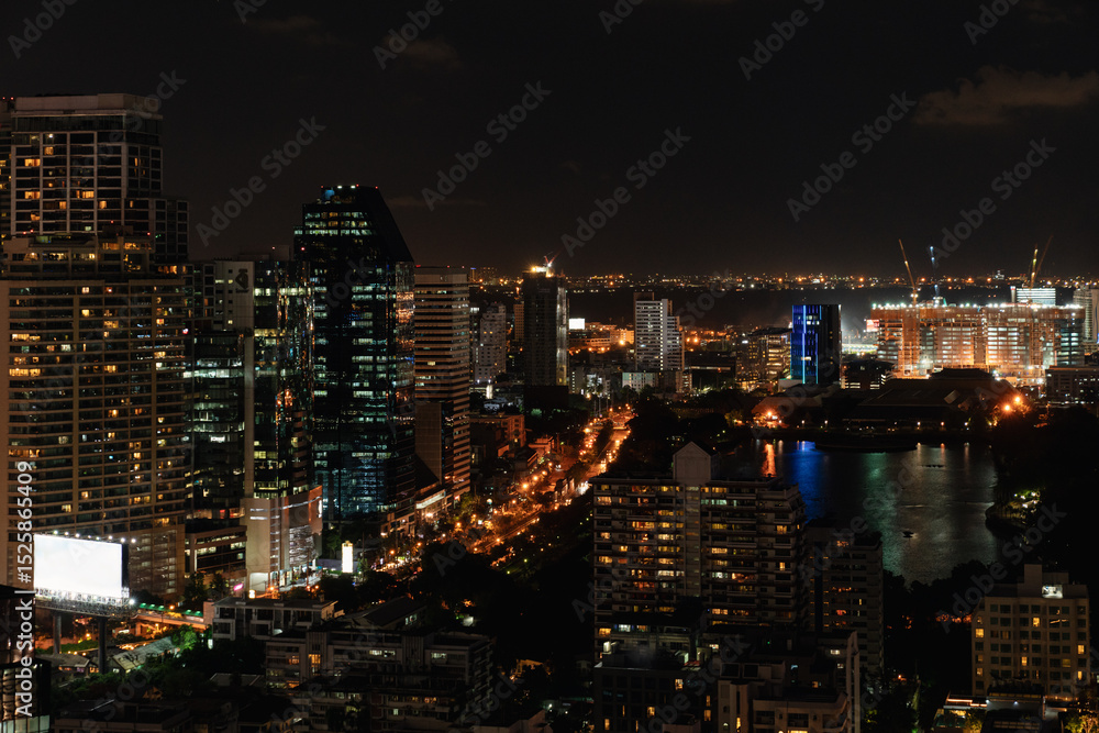 Obraz premium Bangkok City Skyline at Night with Reflections and Illuminated Streets