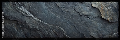 Close-up view of dark textured rock surface with natural cracks and layers