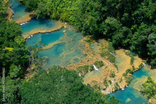 Aerial photograph of the Semuc Champey River during the day with turquoise pools of water, with water flowing surrounded by mountains