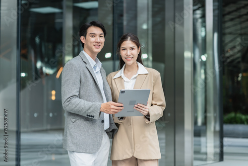 Fotografie Confident Asian Business Team Posing Outside Modern Office Building in the City