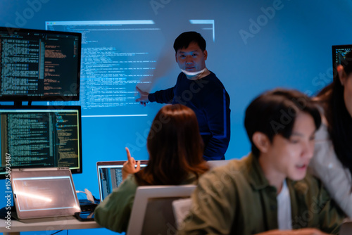 Wall Mural Asian software engineer or programmer team working late in development office,problem solving or algorithm of ai assistant helping for work