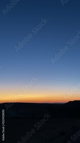 Wallpaper Mural Pan across empty desert terrain with mountains and plains during sunset or sunrise with colorful romantic sky with warm orange and yellow. Dusk or dawn in natural landscape view user content style Torontodigital.ca