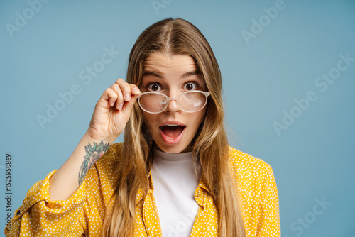 Canvas Print Surprised woman lowering glasses with amazed expression, opening mouth in astoni