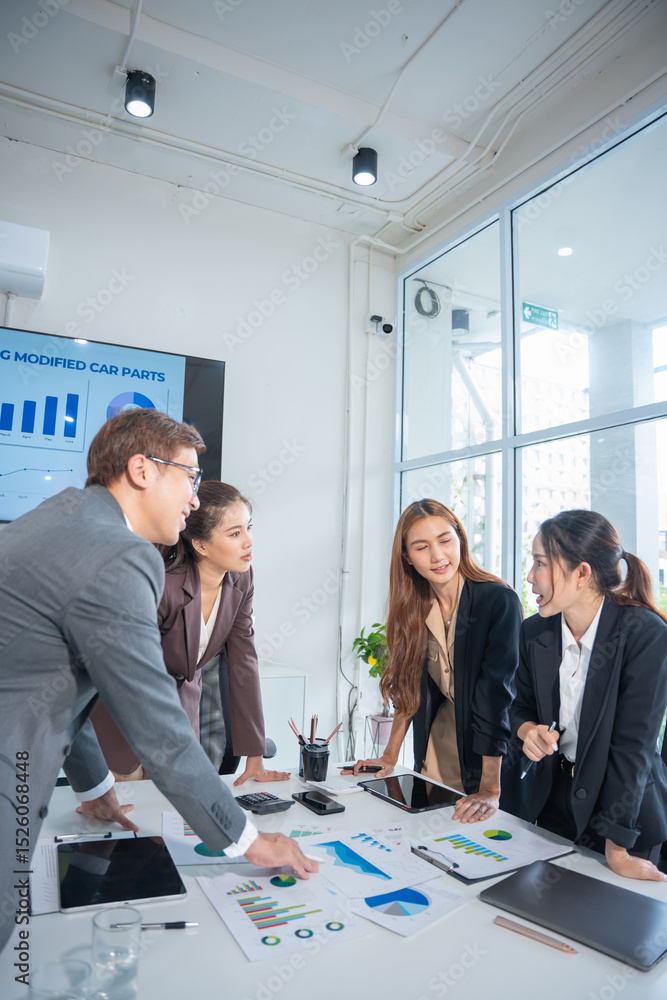 © panomporn - Group of confident professional business people pointing at graphs and charts to analyze marketing data to plan new sales strategies to increase productivity in modern office. © panomporn - Group of confident professional business people pointing at graphs and charts to analyze marketing data to plan new sales strategies to increase productivity in modern office.