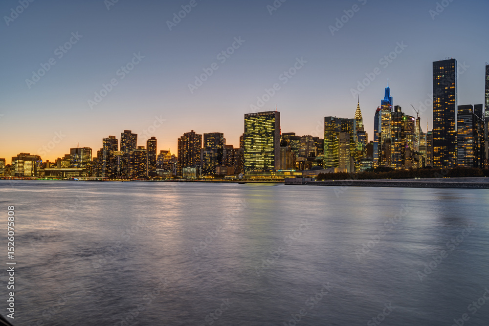Fototapeta premium The skyline of Midtown Manhattan with the Chrysler Buidling and the UN-Building after sunset