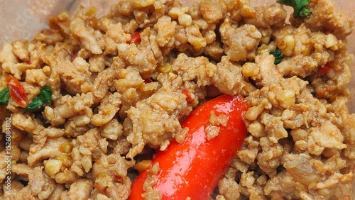 Canvas-taulu Close-up of cooked ground meat mixed with spices and a red chili pepper, showcasing a flavorful and textured dish