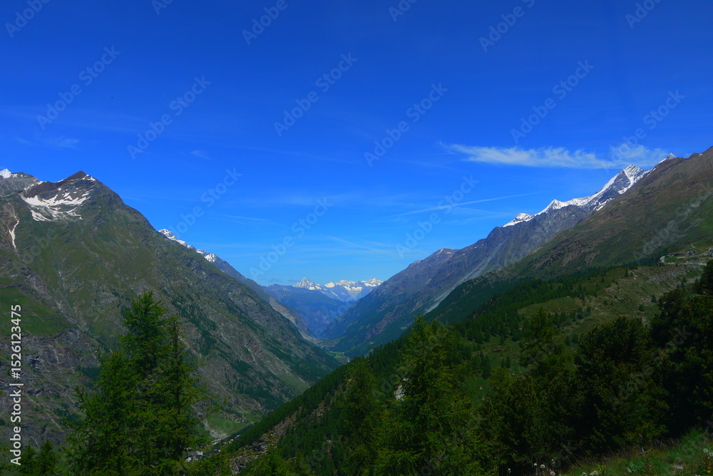 Fototapeta premium mountain landscape with snow-capped peaks and crystal clear blue sky in summer, Switzerland
