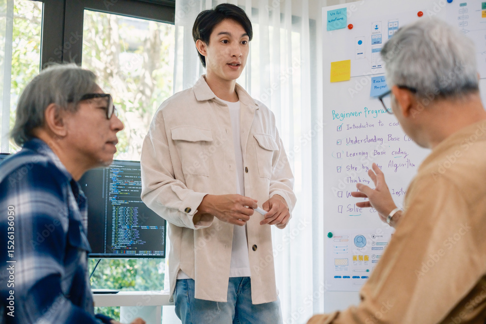 Fototapeta premium senior programmer bootcamlp,Asian young instructor guides senior learners through a programming on whiteboard, highlighting algorithm thinking and simple code exercises