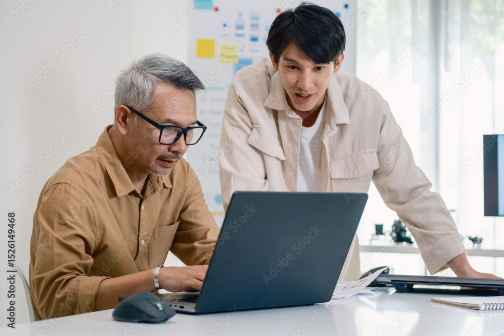 Obraz premium Asian Instructor Teaching Senior in Software Programming and Training Collaboration