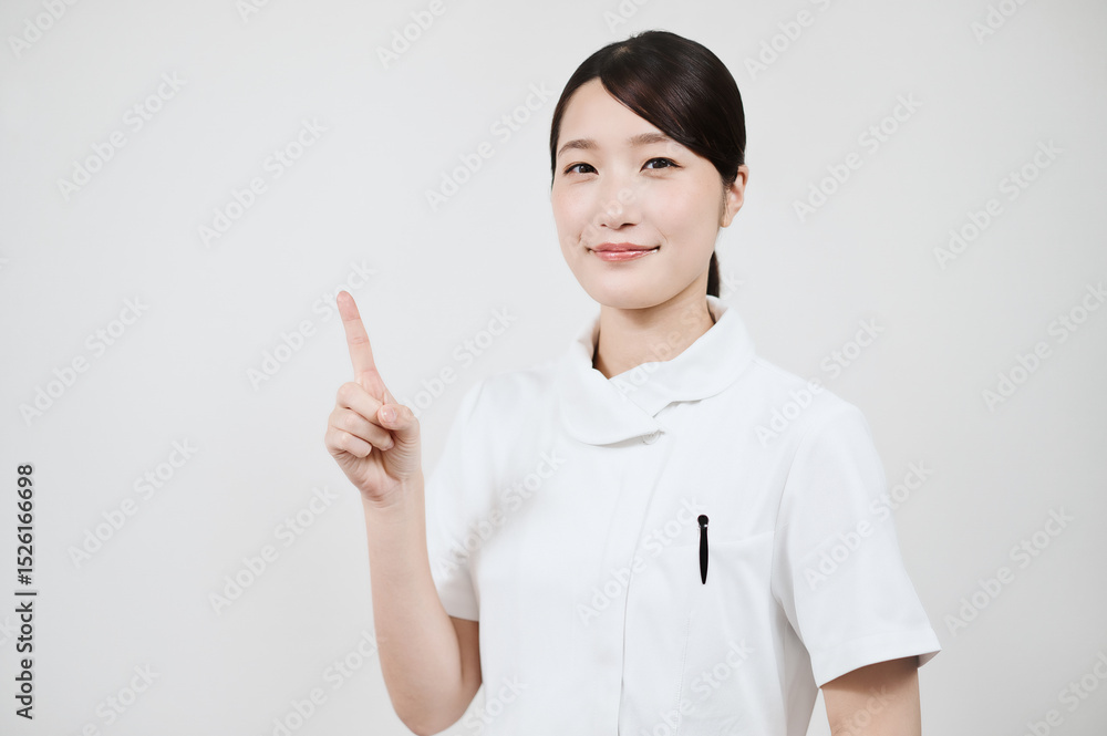 指さしのポーズをする白衣の女性 指さしのポーズをする白衣の女性