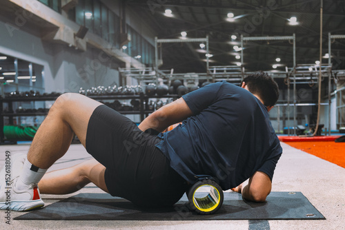 A young Asian boy with a well-defined athletic physique is captured on an athletic oval, likely within a gym