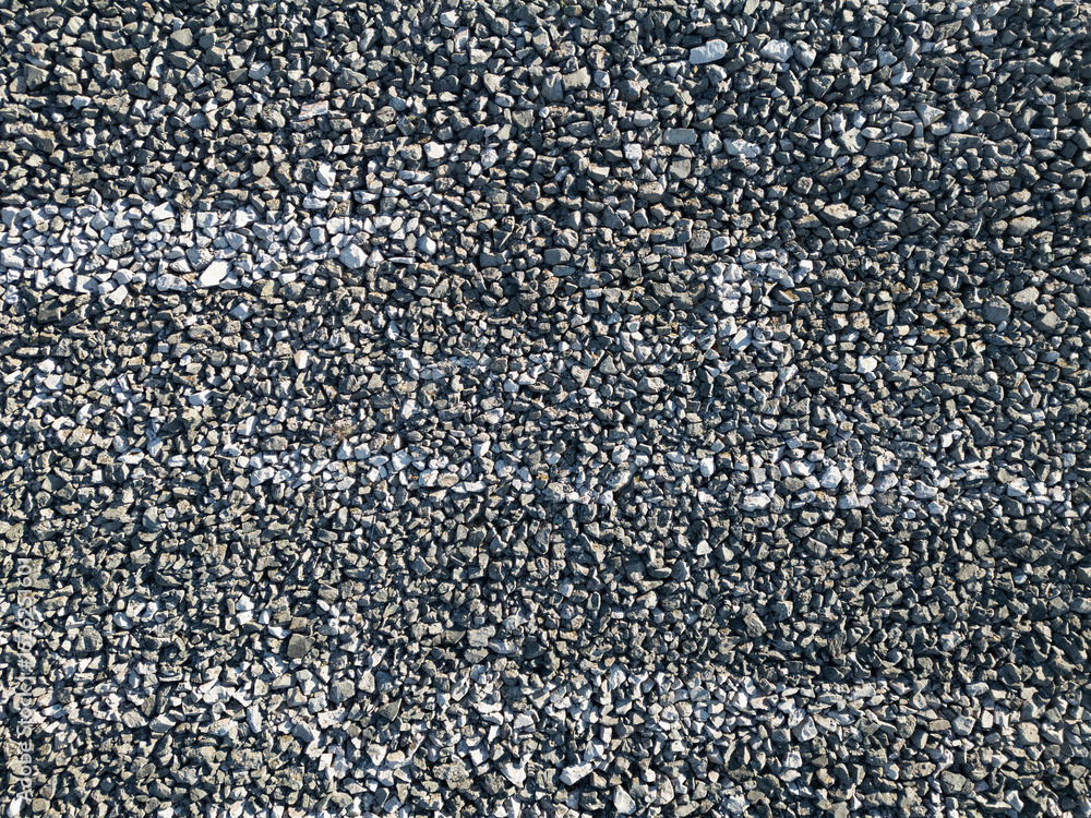 Fototapeta premium Abstract texture and background of grey crushed stone covering the surface of a rock-fill hydropower dam in the mountains of Norway.
