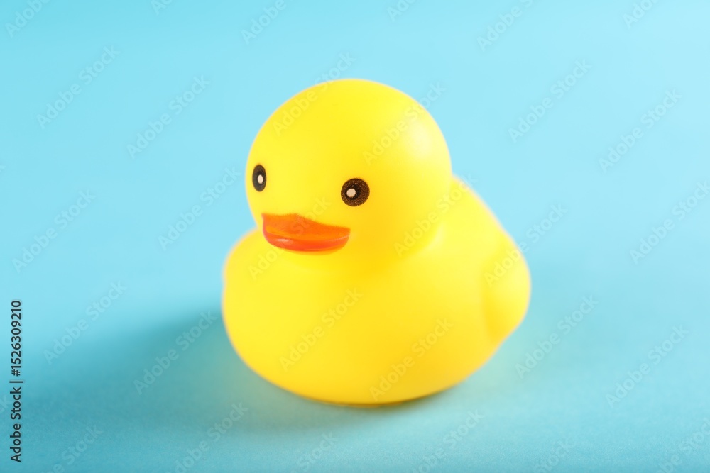 One cute rubber duck on light blue background, closeup One cute rubber duck on light blue background, closeup
