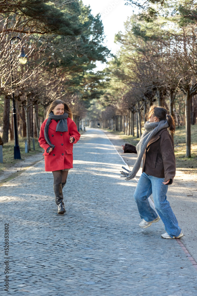 Two women walking in the park. Friends walking on a path in the park. Nature. Two women walking in the park. Friends walking on a path in the park. Nature.