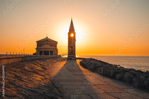 Obraz na plátně Sunrise Over Church Tower in Caorle, Italy

Magical sunrise at the Adriatic coast in Caorle, Italy, with the rising sun forming a perfect star through the church tower