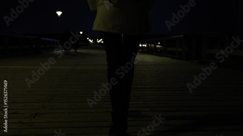 Slow motion view of woman walking alone, during the night. Stalker following victim. Dark night view, female legs.