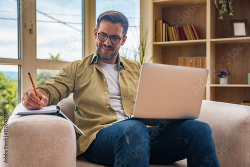 Young home-based online therapist in virtual counseling session, focused mental health professional listening to client on video call taking notes offering support and empathy in calm domestic setting
