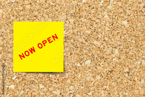 Yellow note paper with word now open on cork board background with copy space