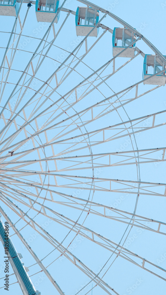 Obraz premium Close view of Ferris wheel cabins on sunny sky background in park setting