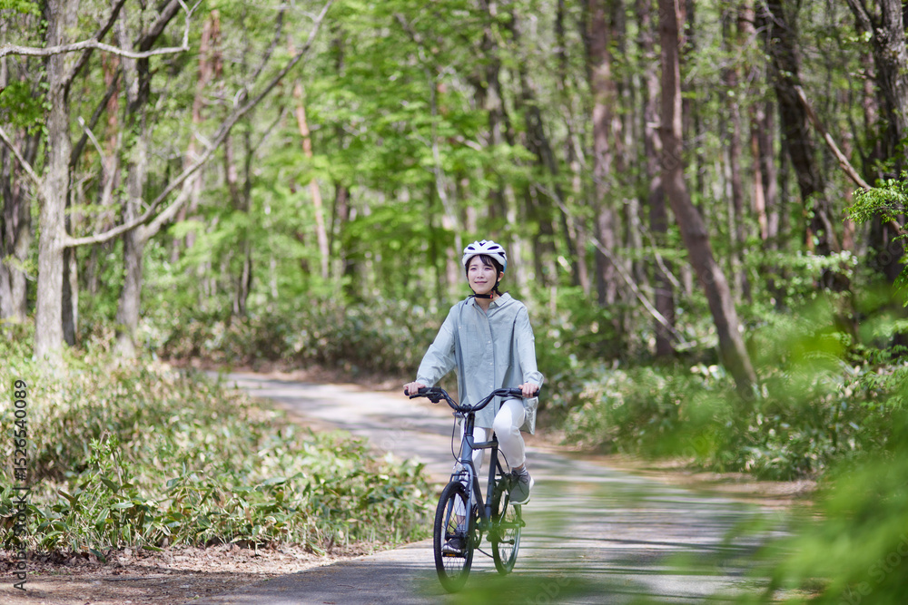 Obraz premium 自然の中でサイクリングを楽しむ日本人の女性