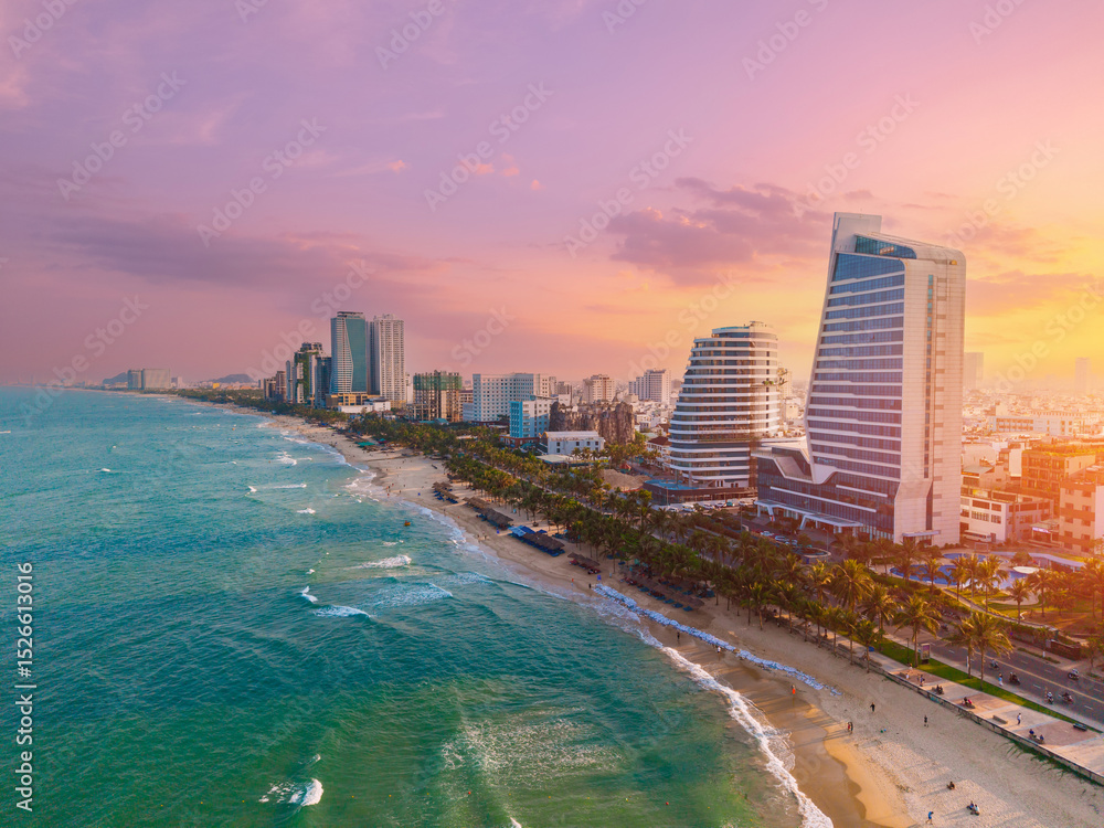 Obraz premium Sunset over Da nang beach skyline with modern architecture and vibrant sky, Vietnam travel