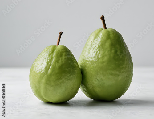 A green guava with smooth skin, realistic fruit photo, minimal style, studio light, white background, Pear on a white background showcasing its fresh and ripe appearance