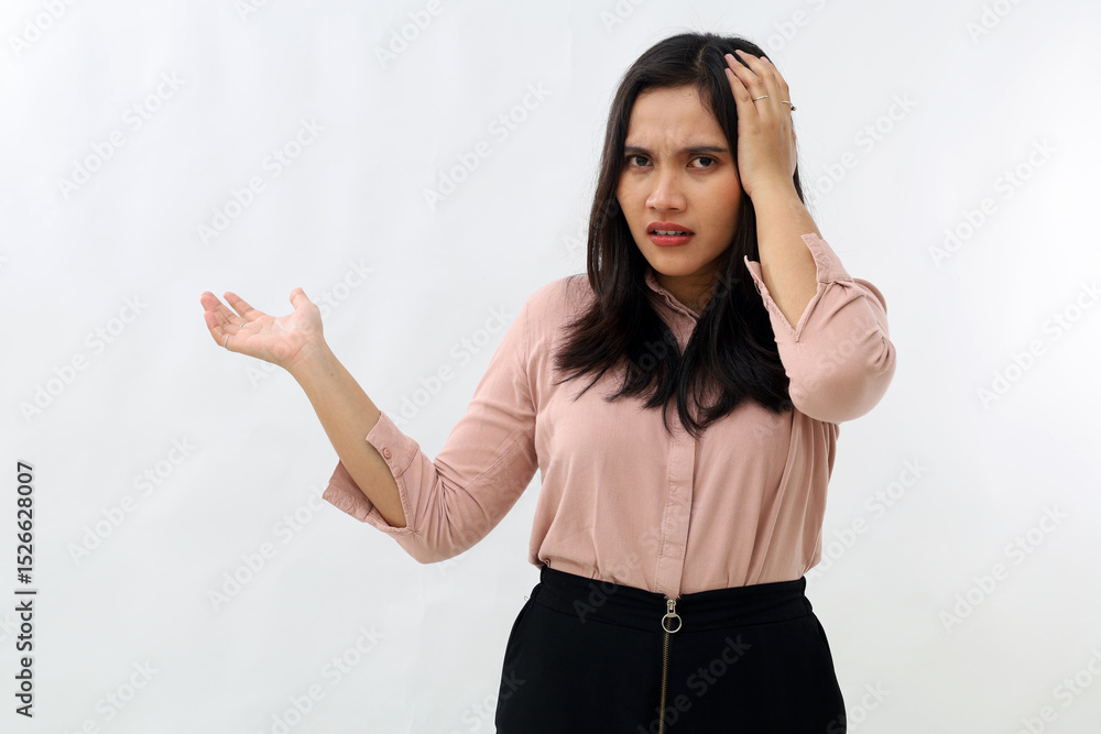 Young Asian woman looking at camera, stressed showing confused gesture while holding her head with unhappy emotion, opening arms to the side, standing on white background. Young Asian woman looking at camera, stressed showing confused gesture while holding her head with unhappy emotion, opening arms to the side, standing on white background.
