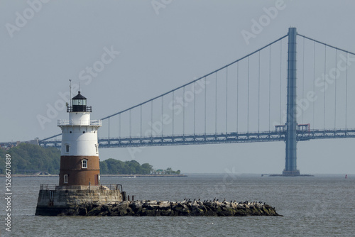 Tableau sur toile small red and white lighthouse with Verrazzano bridge in the background (brookly
