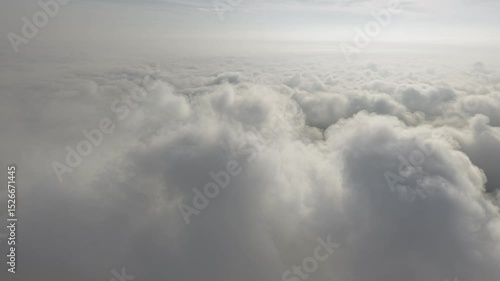 A stunning aerial view capturing the serene beauty of clouds from above. Soft, billowing formations stretch across the sky, bathed in golden sunlight.