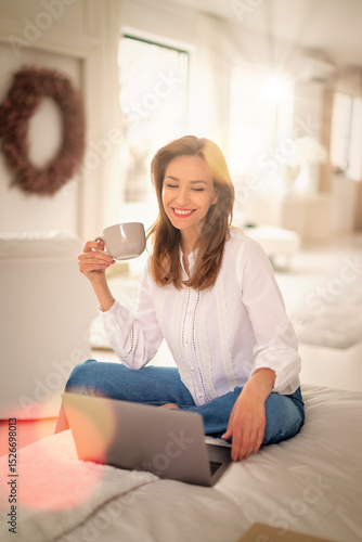 Wallpaper Mural Middle aged woman sitting at home and using a computer laptop Torontodigital.ca