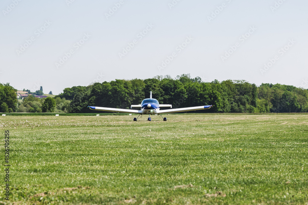 Fototapeta premium An airplane on a grass runway. The aircraft is ready to fly. It's a transportation for people