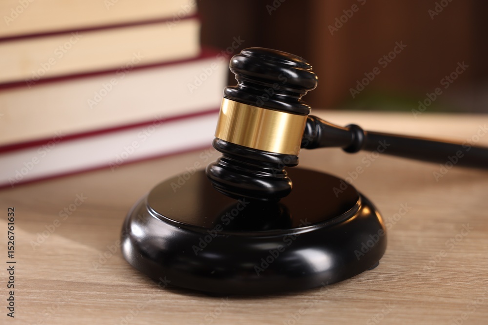 Judge's gavel and books on wooden table indoors, selective focus Judge's gavel and books on wooden table indoors, selective focus