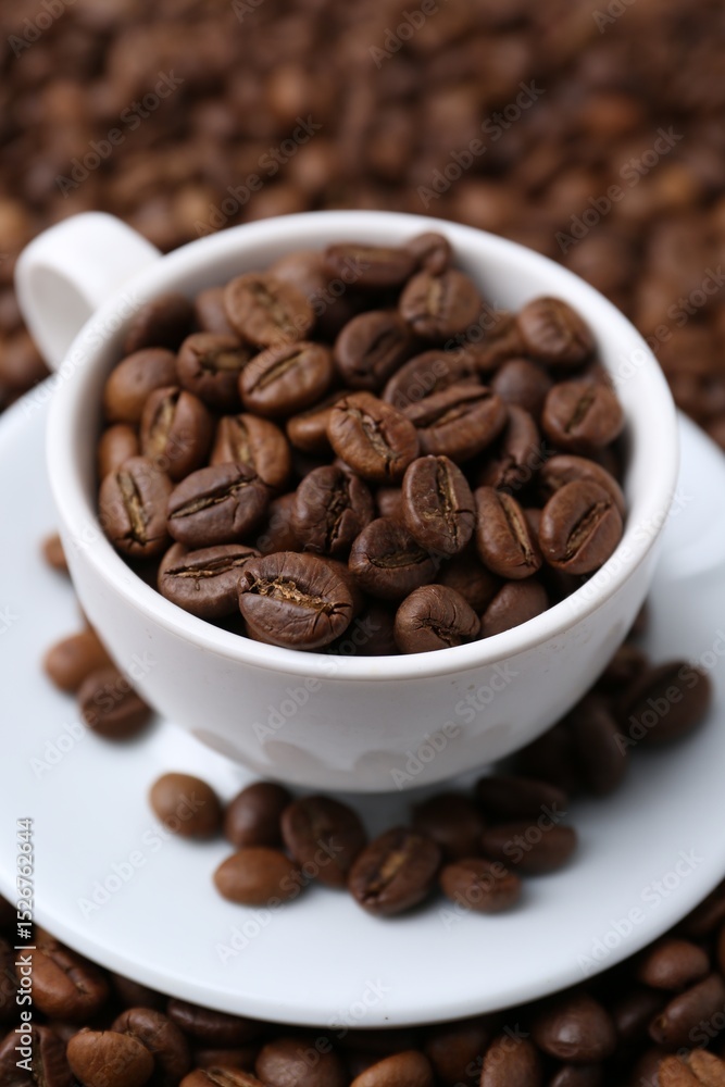 Fototapeta premium Cup and saucer on coffee beans, closeup