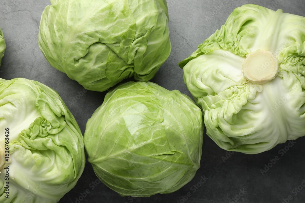 Fototapeta premium Fresh green cabbages on grey table, flat lay