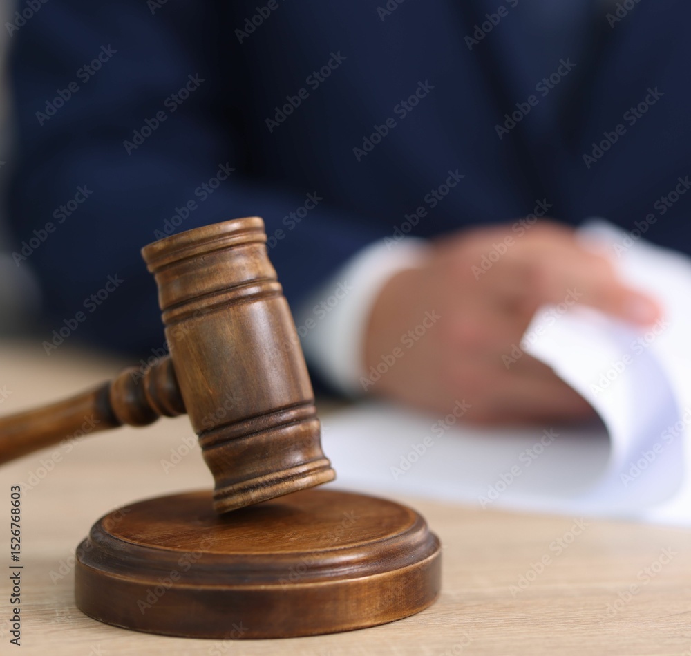Judge working and gavel on desk indoors, selective focus Judge working and gavel on desk indoors, selective focus