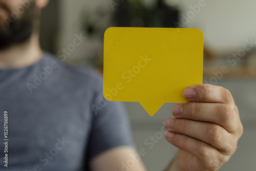 A man holds a yellow speech...