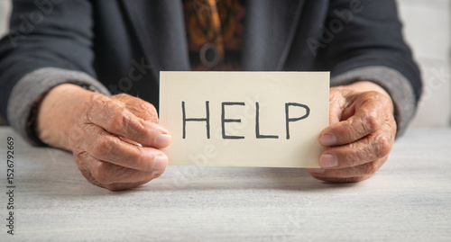 Slika na platnu Elderly woman showing Help message on paper.