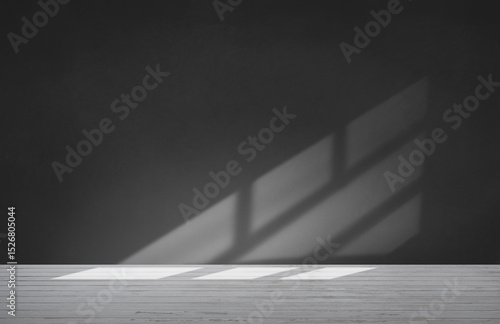 A black and white photo of a room with a window shadow