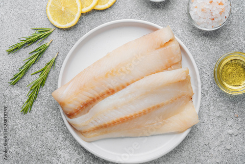 Fototapeta Naklejka Na Ścianę i Meble -  Raw pollock fillet with seasoning ingredients on gray background