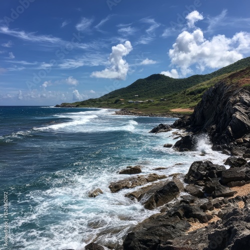 Coastal scenery with the ocean waves crashing against the rocky shoreline. The blue water meets the sky on a sunny day. A serene moment to take in the beauty of nature.