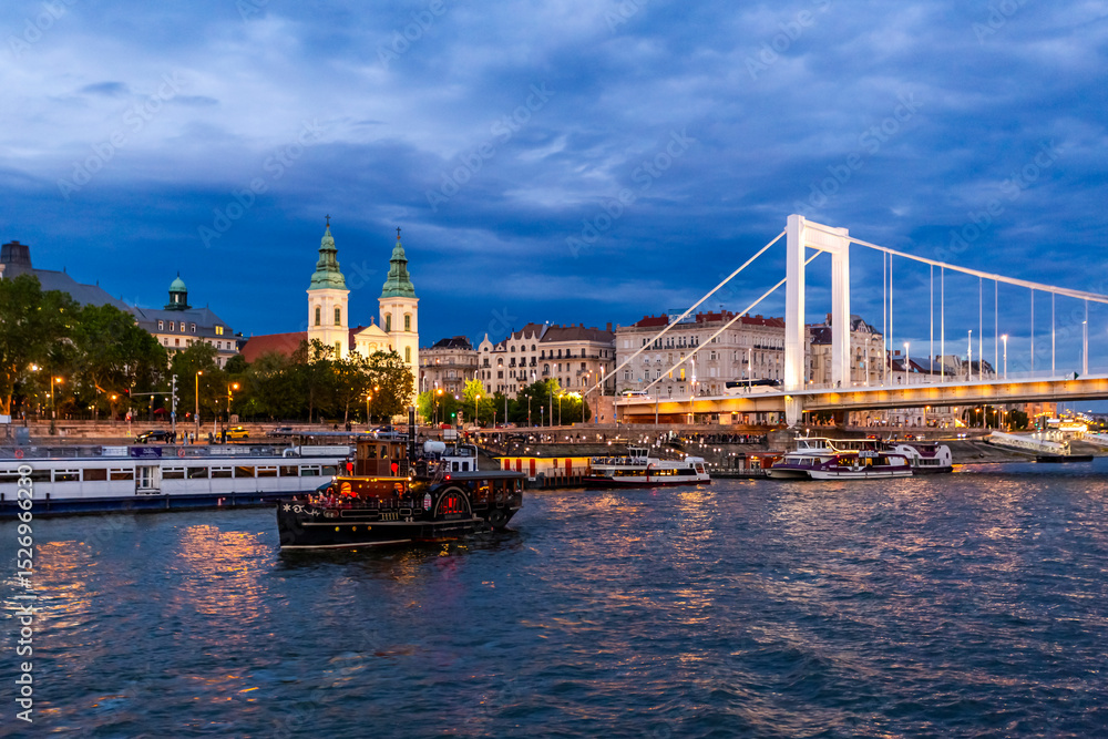 Obraz premium Beautiful view of the historical buildings and the Elisabeth Bridge illuminated in twilight in Budapest, Hungary