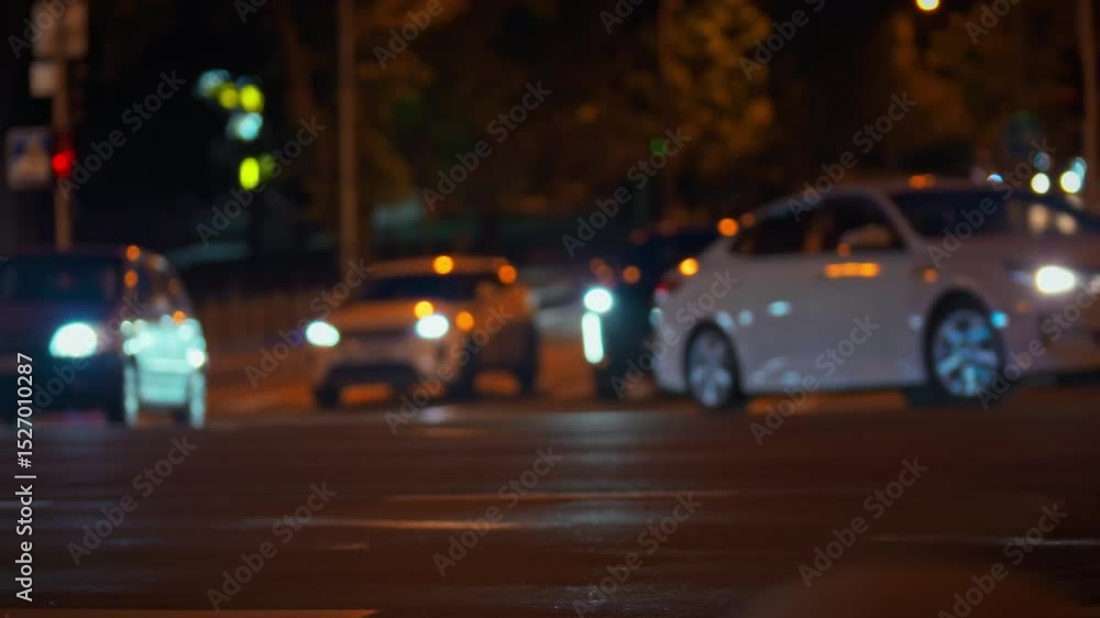 Vehicles navigate a busy intersection under city lights at night. The blurred motion captures the sense of movement and activity typical of urban life Vehicles navigate a busy intersection under city lights at night. The blurred motion captures the sense of movement and activity typical of urban life