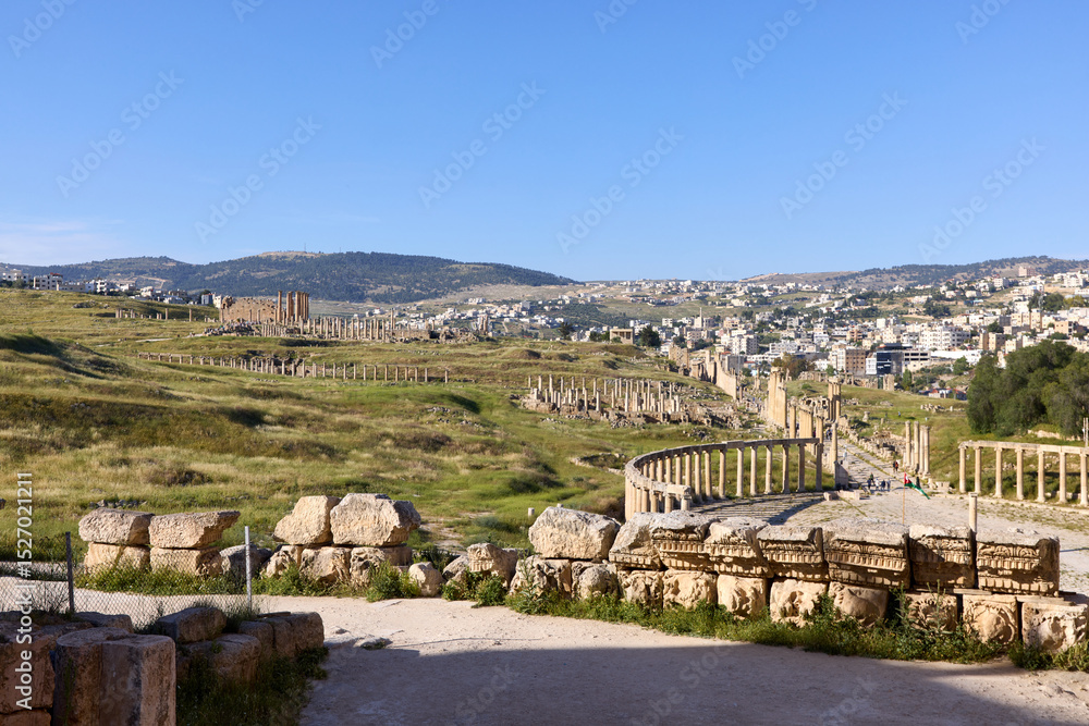 custom made wallpaper toronto digitalVisitors explore the ancient site of Jerash in Jordan, admiring well-preserved Roman ruins, columns, and the lush green landscape surrounding the historic city.