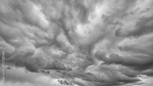 A swirling mass of dark, brooding clouds dominates the sky, their weighty forms creating a dramatic grayscale spectacle