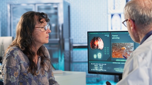 Photos Physician consulting a patient about an MRI scan providing diagnostics insights into tumor growth and potential chemotherapy options in a modern healthcare office