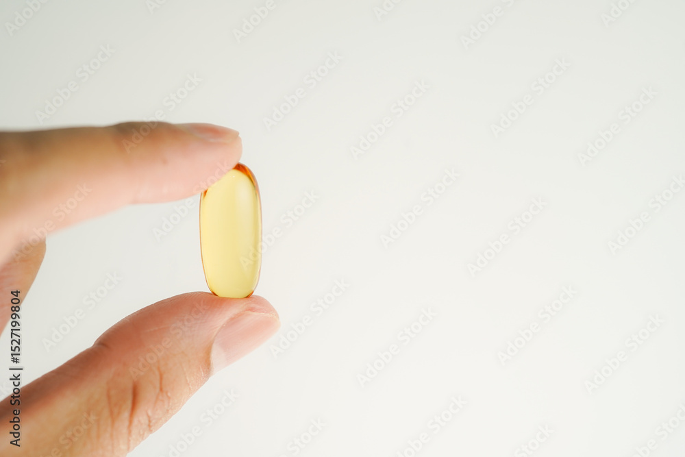 Male hand holding Oil filled capsules, softgel of food supplements, fish oil, omega 3, vitamin E Male hand holding Oil filled capsules, softgel of food supplements, fish oil, omega 3, vitamin E