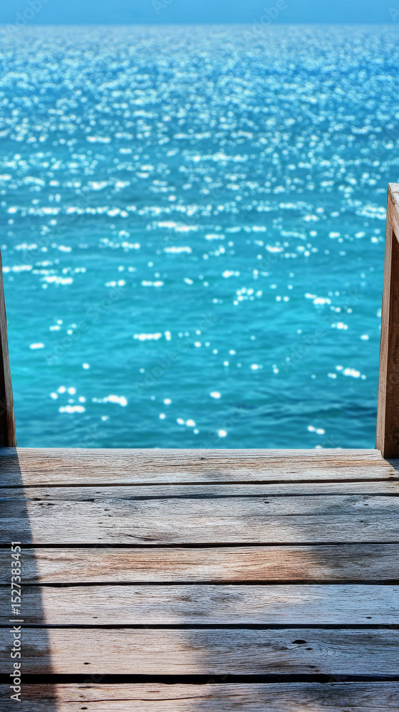 Obraz premium Wooden pier overlooking sparkling turquoise ocean water. Serene seascape ideal for relaxation and tropical escapes.