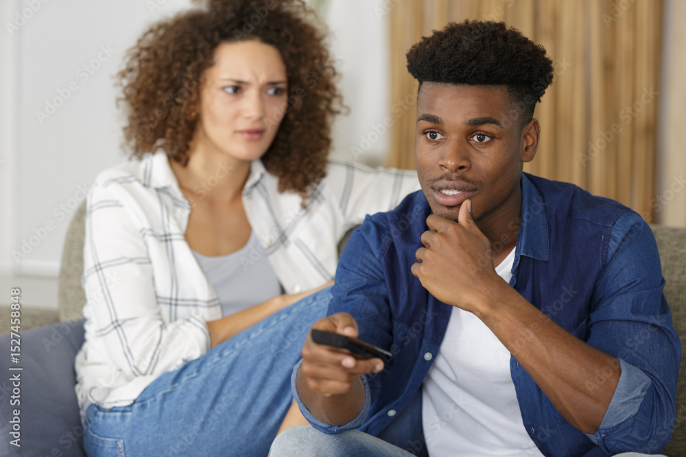 Fototapeta premium upset young woman while boyfriend prefers tv