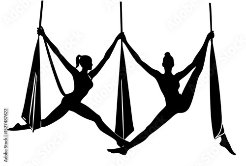 Aerial yoga silhouettes two women in a dynamic pose